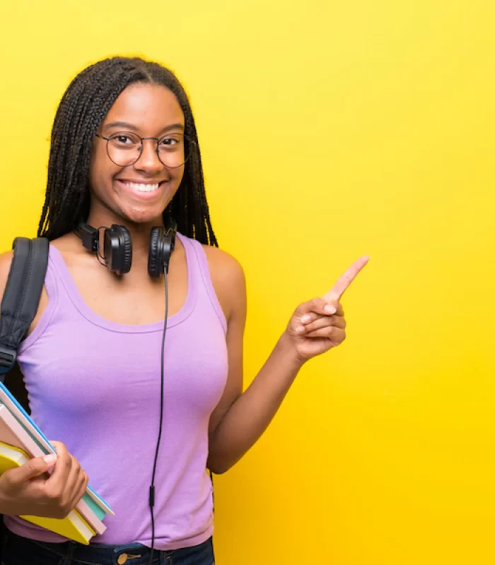 african-american-teenager-student-girl-with-long-braided-hair-yellow-wall-pointing-finger-side_1368-50825